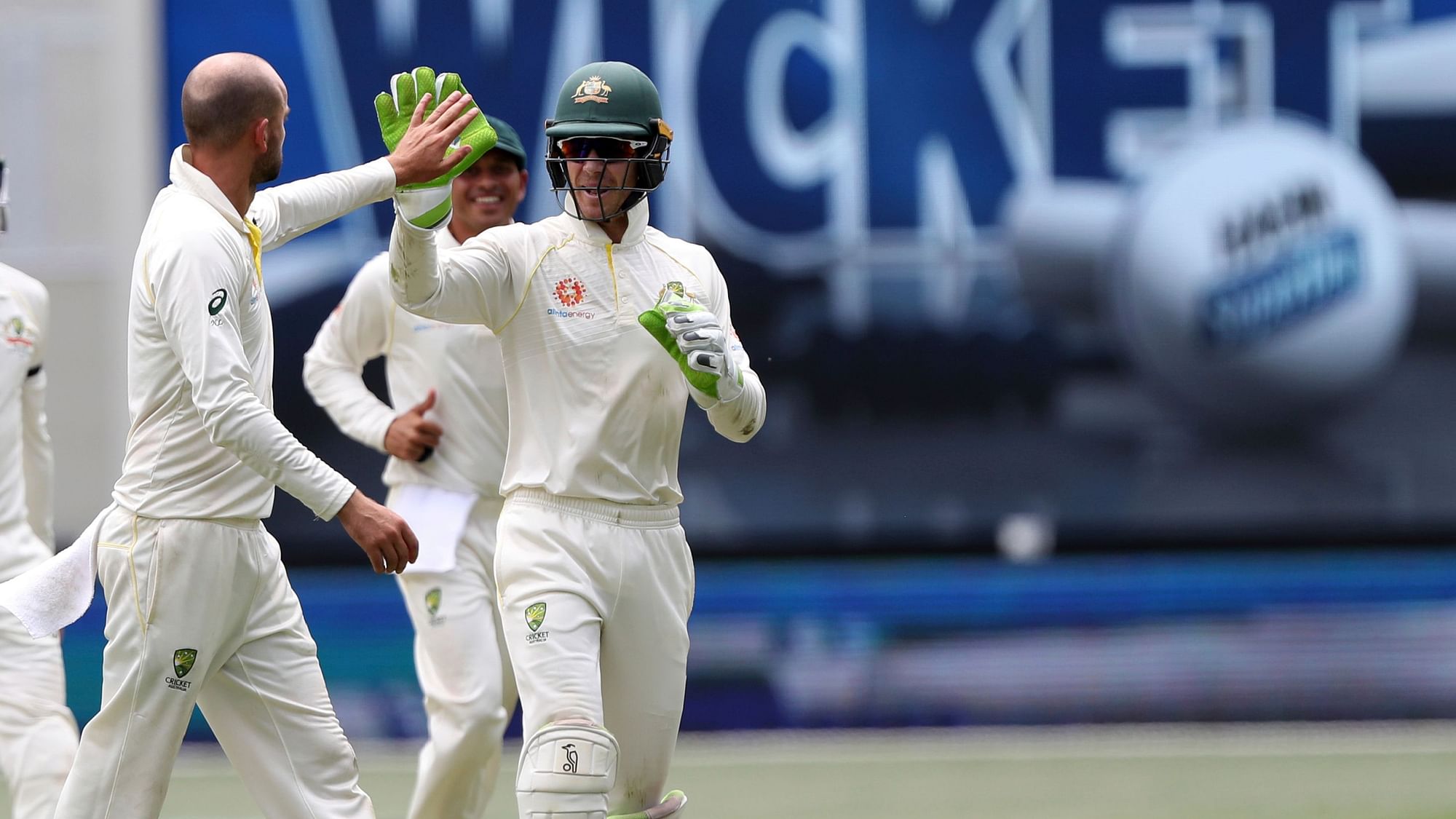 Australian skipper Tim Paine celebrates the fall of an Indian wicket with teammates Nathan Lyon in the second Test.