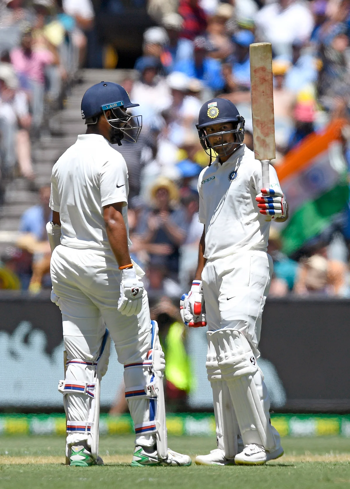 India’s Mayank Agarwal, right celebrates with team mate, left Cheteshwar Pujara after scoring a half century on day one of the third cricket test between India and Australia in Melbourne, Australia, Wednesday, Dec. 26, 2018. 