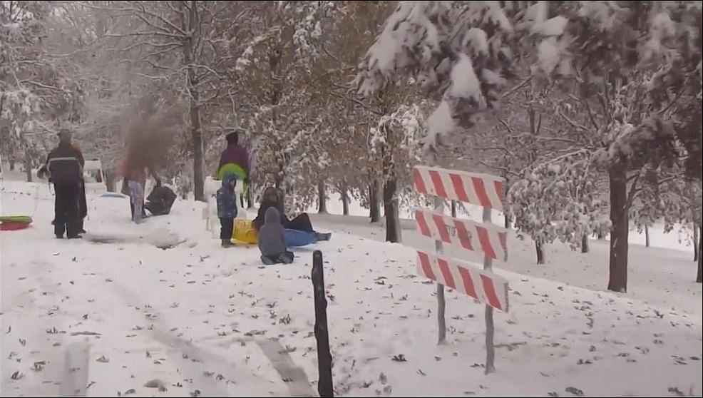 Parents playing with children in snow.