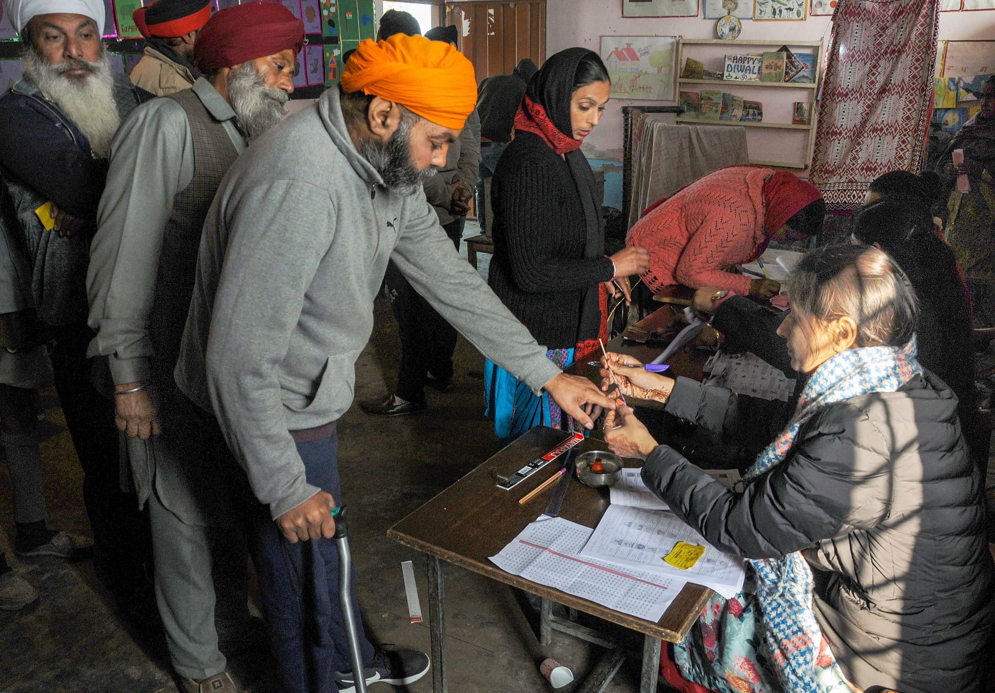 An election officer puts indelible ink mark on the finger of a voter at a polling station during Punjab Panchayat elections, on the outskirts of Amritsar, Sunday, 30 December 2018.&nbsp;