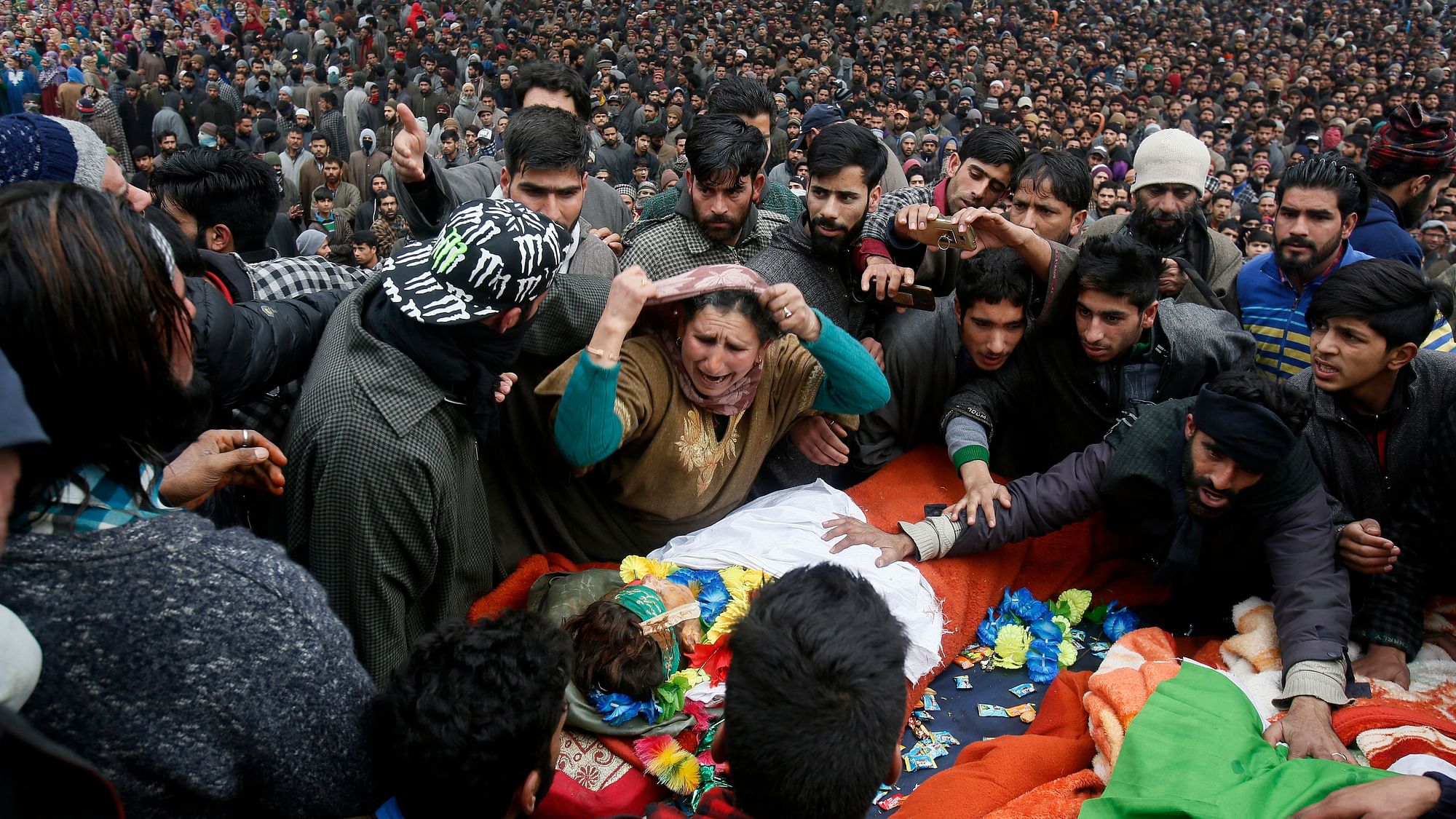 An unidentified relative weeps near the body of Mudasir Rashid Parray during joint funeral of teenage rebels Saqib Bilal Sheikh and Parray at Hajin village, north of Srinagar,  Kashmir, on Monday, 10 December. Thousands of people in Kashmir joined the funeral procession of the rebels  killed over the weekend in a long gun battle with Indian troops in the disputed region.