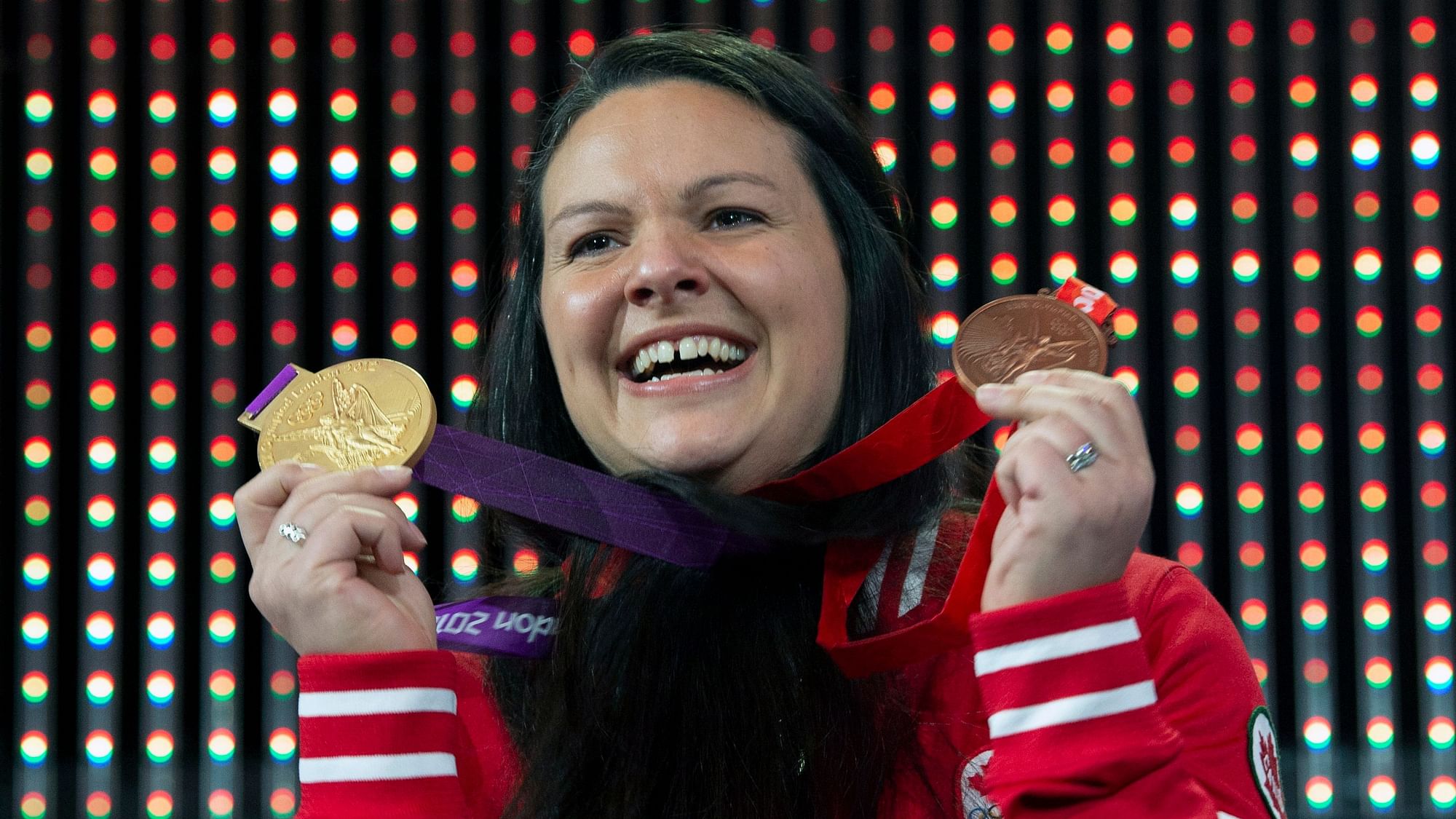Canadian weightlifter Christine Girard holds up the gold and bronze Olympic medals she was awarded during a ceremony in Ottawa,.