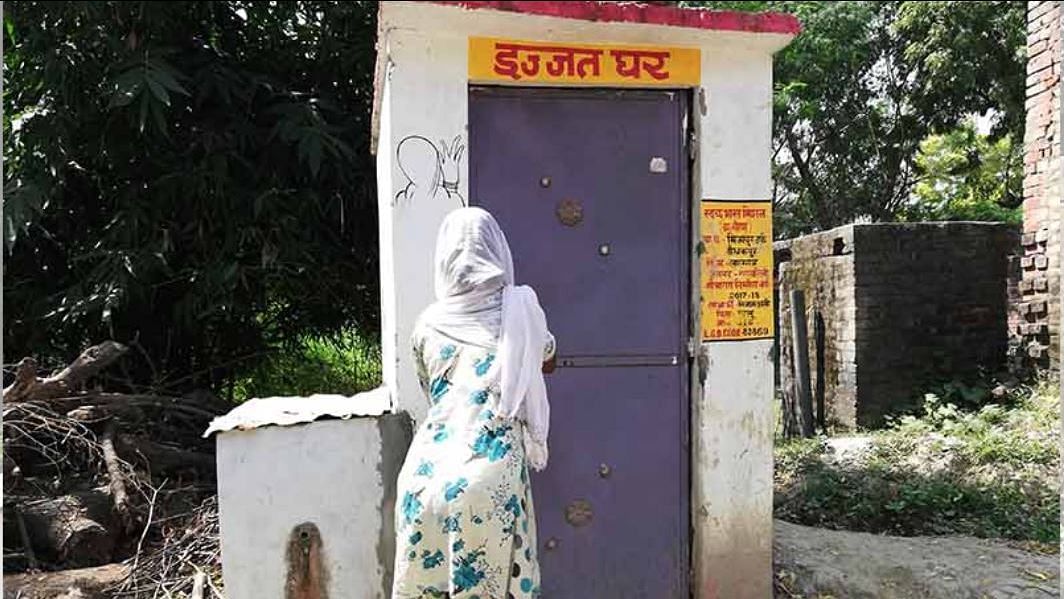 A woman in Rae Bareli, Uttar Pradesh, standing near a latrine supported by the government in October 2018.