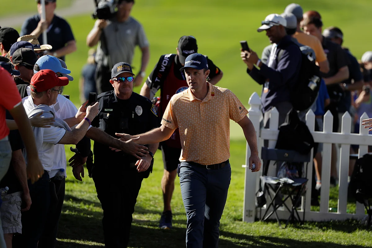 Justin Rose, of England, greets fans as he makes his way to the 14th hole of the South Course at Torrey Pines Golf Course during the final round of the Farmers Insurance golf tournament Sunday, Jan. 27, 2019, in San Diego. 