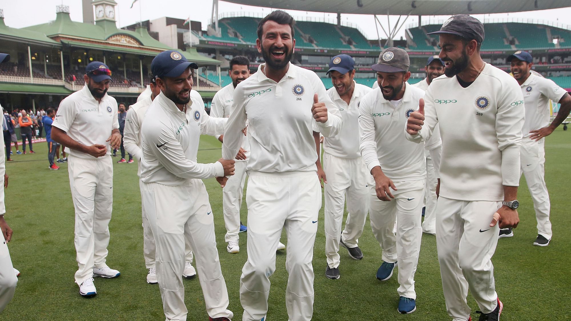 The Indian team members try to make Cheteshwar Pujara shake his leg after a historic Test series win in Australia.