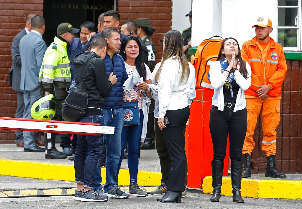 Family members of victims gather outside the entrance to the General Santander police academy where the bombing took place.