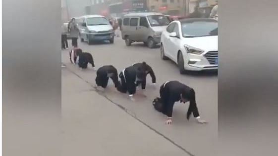 Chinese employees forced to crawl on street as punishment.
