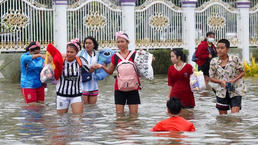 Thai people wade through floodwaters from Tropical Storm Pabuk on Friday, 4 January in the southern province of Nakhon Si Thammarat in southern Thailand. 