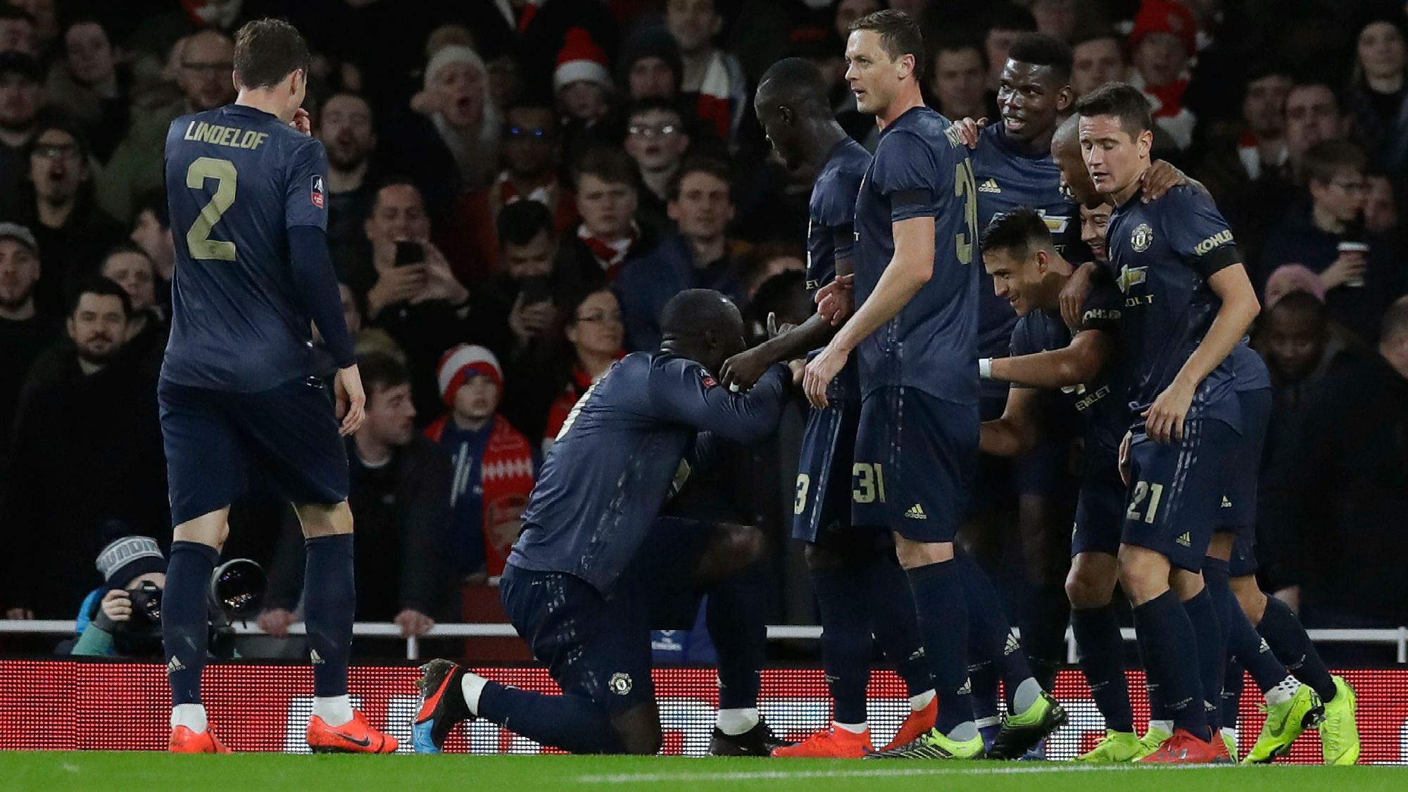 Manchester United’s Alexis Sanchez celebrates with teammates after scoring his side’s opening goal during the English FA Cup fourth round  match between Arsenal and Manchester United at the Emirates stadium in London on Friday, Jan. 25.