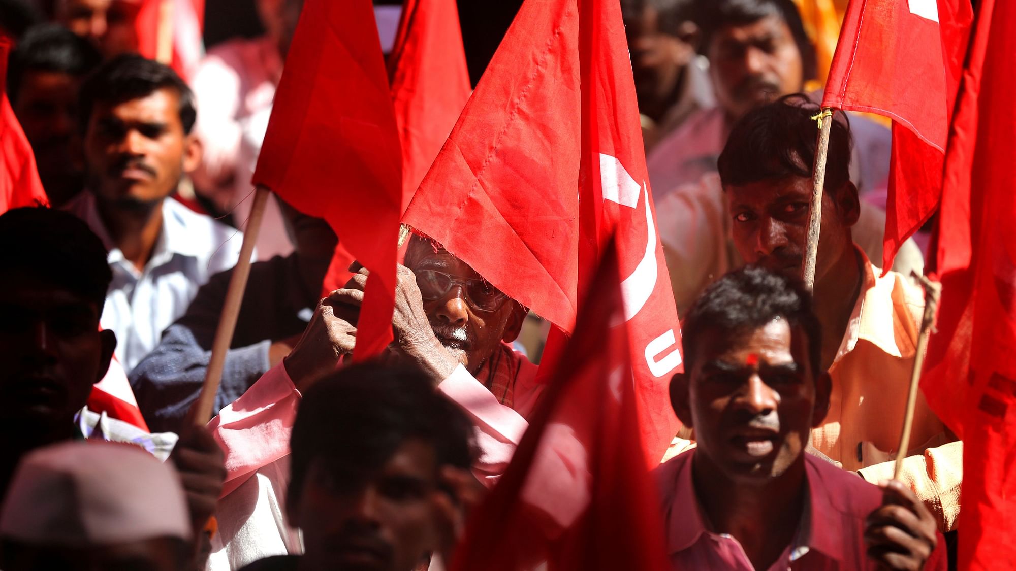 Trade union members hold flags as they participate in a demonstration on the first day of a two-day general strike called by various trade unions in Mumbai, India.