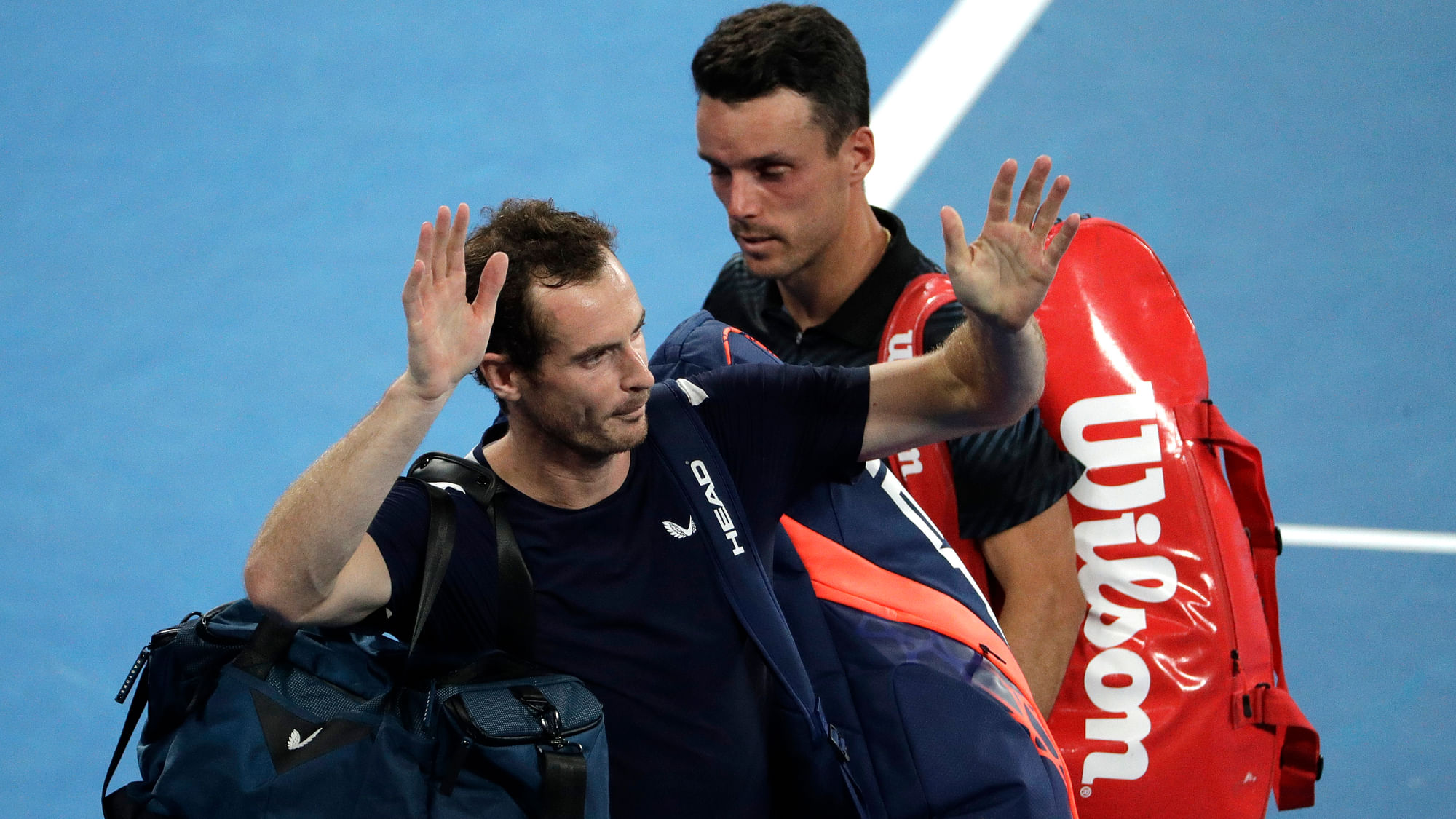 Britain’s Andy Murray, left, waves as he leaves the court following his first round loss to Spain’s Roberto Bautista Agut, right, at the Australian Open tennis championships in Melbourne, Australia, Monday, Jan. 14, 2019.&nbsp;