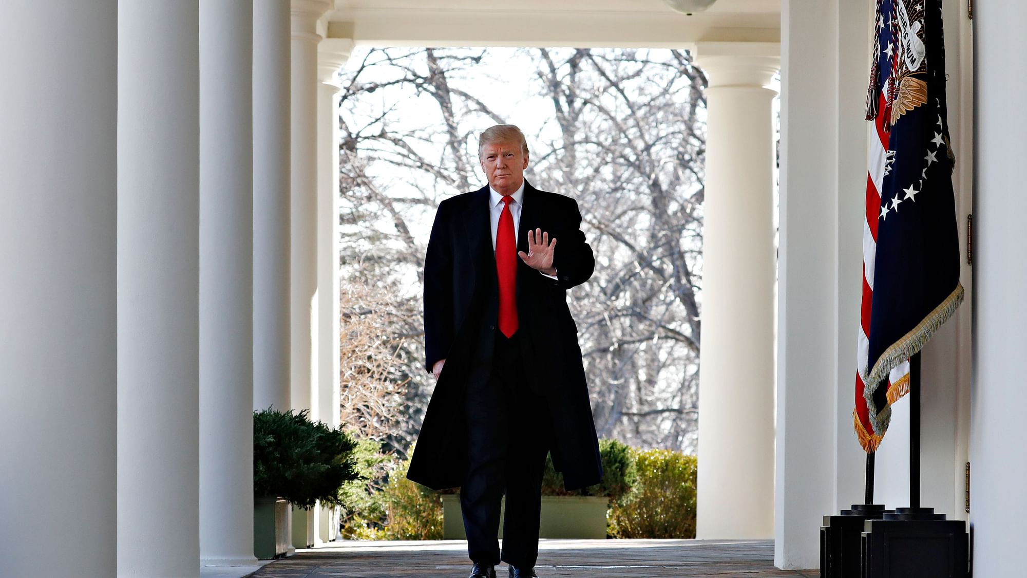 &nbsp; President Donald Trump waves as he walks through the Colonnade from the Oval Office of the White House on arrival to announce a deal to temporarily reopen the government