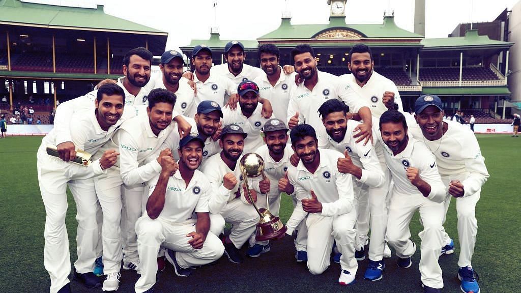 Indian players pose with the Border-Gavaskar Trophy after clinching their maiden Test series win in Australia.