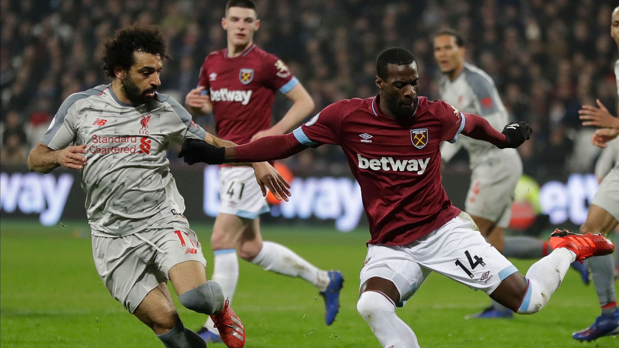 Liverpool’s Mohamed Salah, left, and West Ham’s Pedro Obiang challenge for the ball during the English Premier League soccer match.