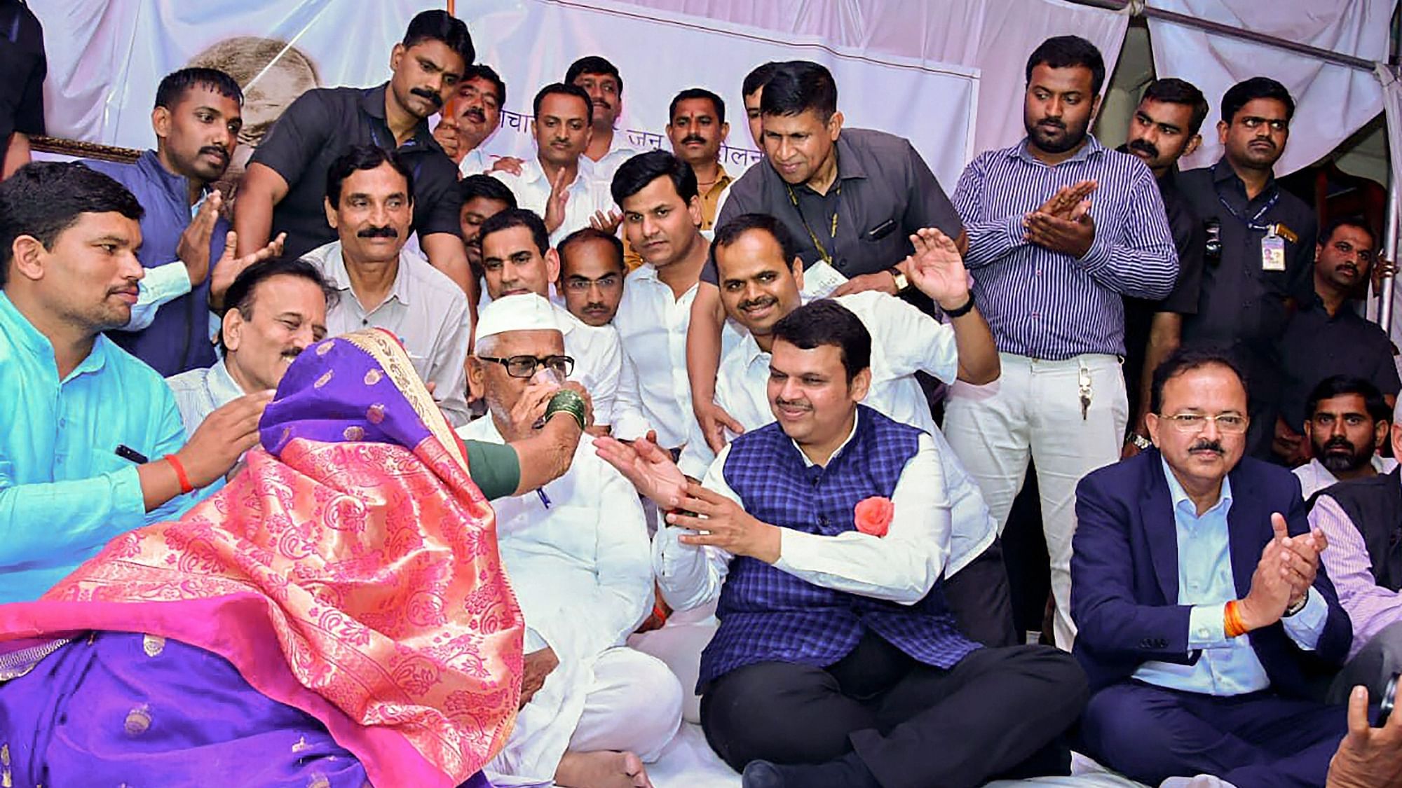 Anna Hazare ends his fast as Maharashtra Chief Minister Devendra Fadnavis and MoS for Defence Subhash Bhamre look on, in the village of Ralegan Siddhi, Ahmednagar.