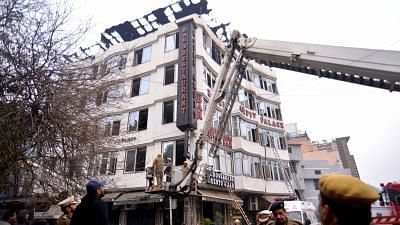 Fire service officials try to douse a fire at Arpit Palace Hotel in Karol Bagh, New Delhi, on 12 February 2019. At least 17 people were killed the blaze.