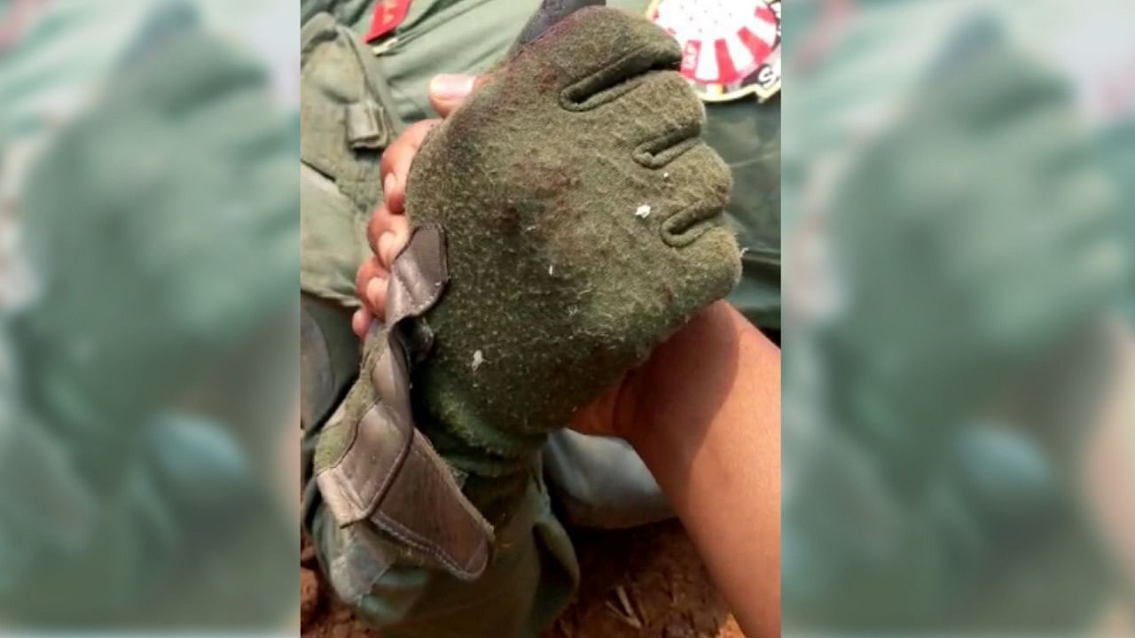 Chetan Kumar, grasping the gloved hand of an injured IAF pilot.