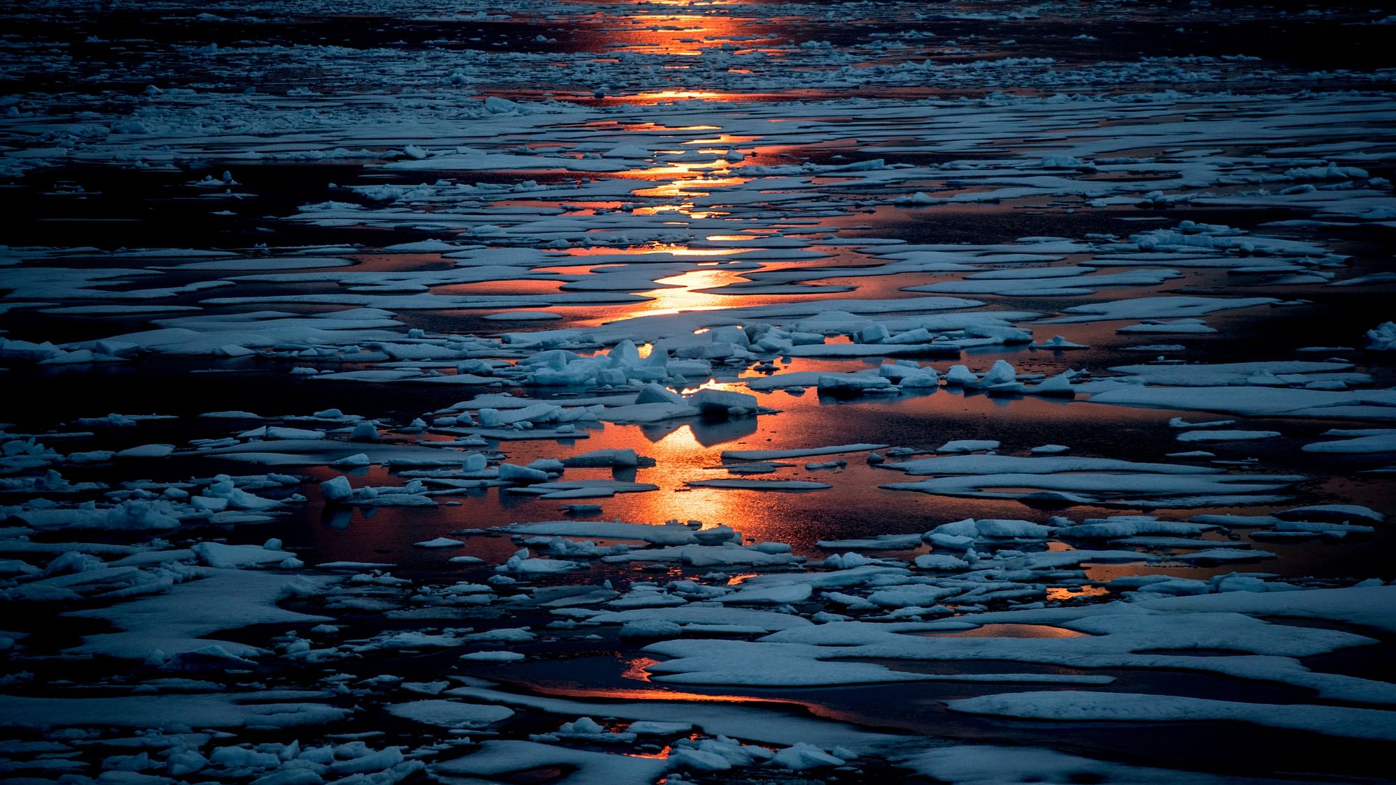 In this 23 July, 2017, file photo the midnight sun shines across sea ice along the Northwest Passage in the Canadian Arctic Archipelago. The magnetic north pole is wandering about 34 miles (55 kilometers) a year. At the end of 2017, it crossed the international date line. That means it’s not even the same day at the new magnetic north pole as it is at the spot of 2010’s magnetic north pole. It’s leaving the Canadian Arctic on its way to Siberia.