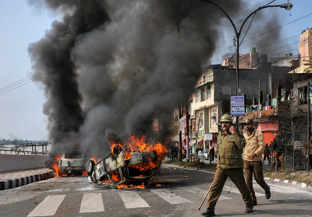 Policemen patrol a street after vehicles set on fire by protestors against the killing of CRPF personnel in the Pulwama terror attack in Jammu. 