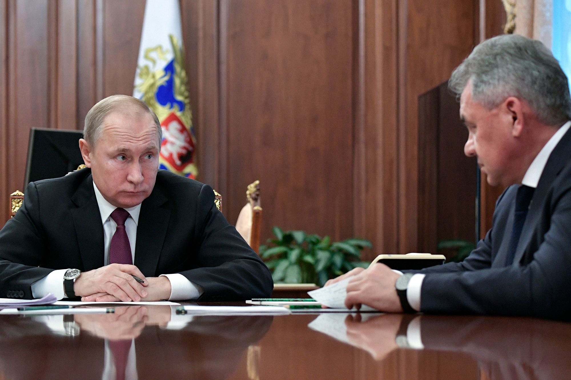 Russian President Vladimir Putin, left, speaks to Defense Minister Sergei Shoigu.
