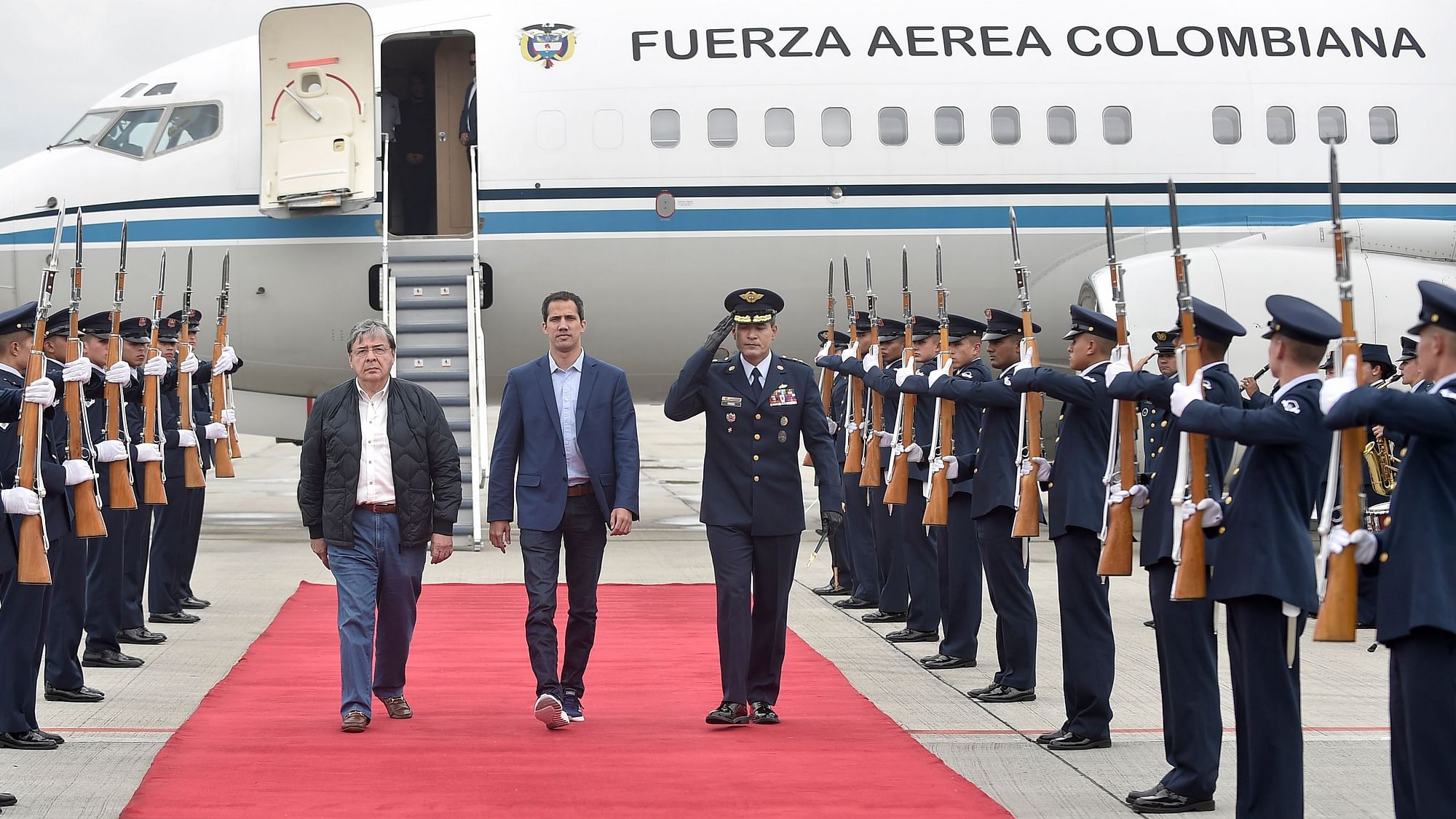 Venezuelan opposition leader Juan Guaido is escorted by Air Force Gen. Luis Carlos Cordoba (R) and Colombian Foreign Minister Carlos Holmes Trujillo during a welcome ceremony for him at the military airport in Bogota, Colombia, Sunday, 24 February.