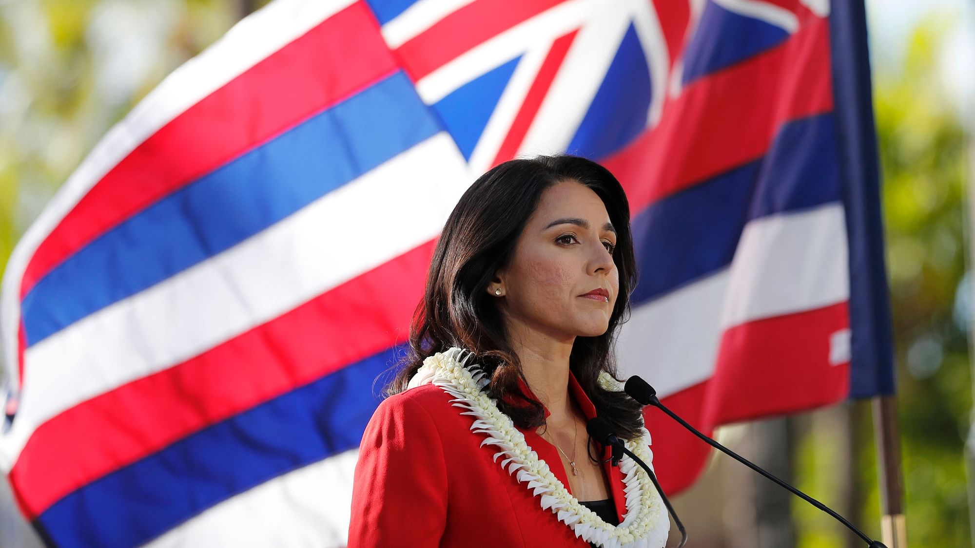As the State of Hawaii flag flies in the background, US Rep Tulsi Gabbard, D-Hawaii, speaks during a campaign rally announcing her candidacy for president in Waikiki.