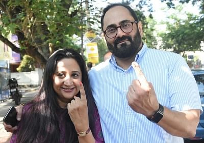 Bengaluru: BJP Rajya Sabha MP Rajeev Chandrasekhar along with his wife Anju Chandrasekhar shows their finger marked with phosphoric ink after casting their vote at a polling booth during Karnataka Assembly Polls at Koramangala Assembly Constituency, in Bengaluru on May 12, 2018. (Photo: IANS)