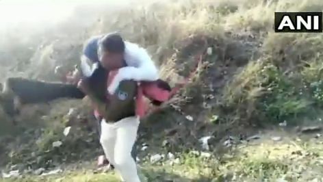 A man fell from a moving train and a constable carries him on his shoulders to safety.&nbsp;