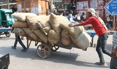 New Delhi: Labors push a cart loaded with sacks, in New Delhi on May 1, 2018. May 1 is observed as International Labour Day. (Photo: IANS)
