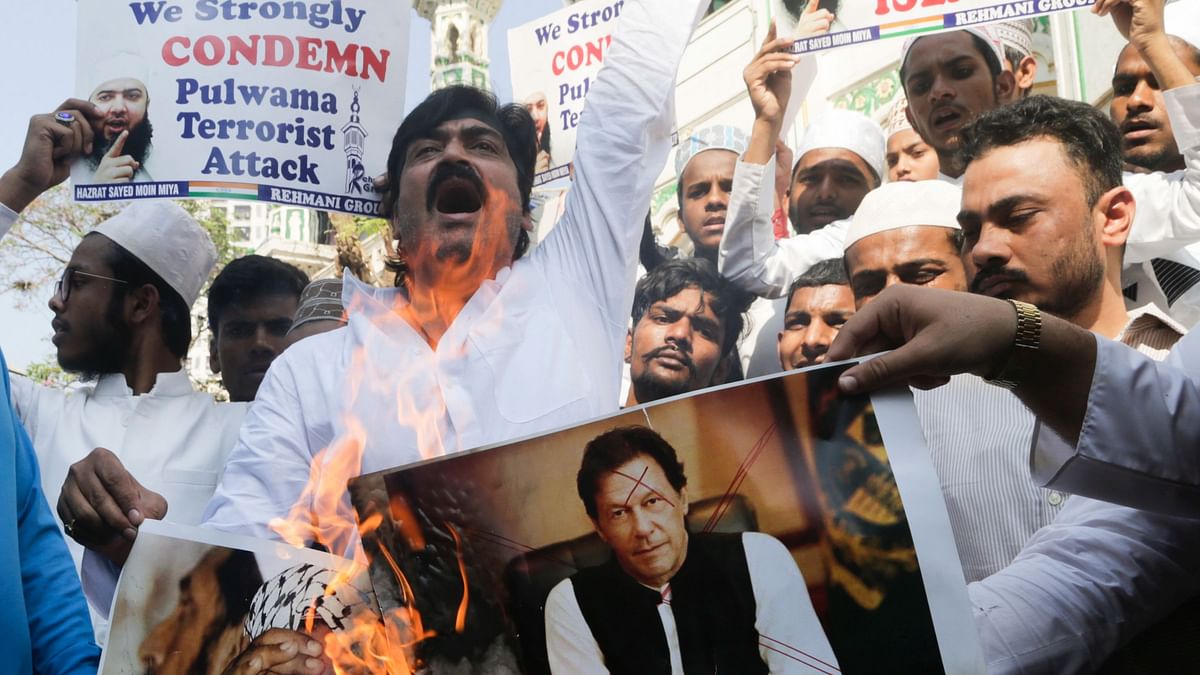 Indian muslims burn posters of Pakistani prime minister Imran Khan, center, and Jaish-e-Mohammed leader Masood Azhar, during a protest against attack on a paramilitary convoy in Kashmir that killed at least 40 CRPF jawaans. 