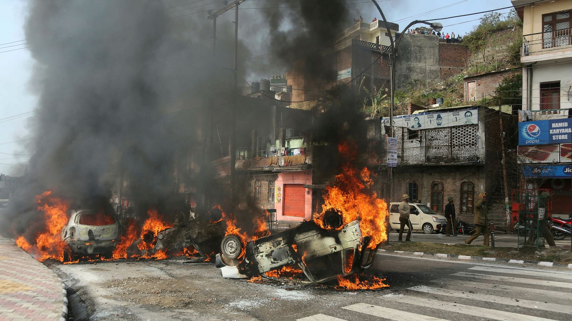 Vehicles stand in flames after it was set on fire by a mob during a protest against Thursday’s attack on a CRPF convoy.
