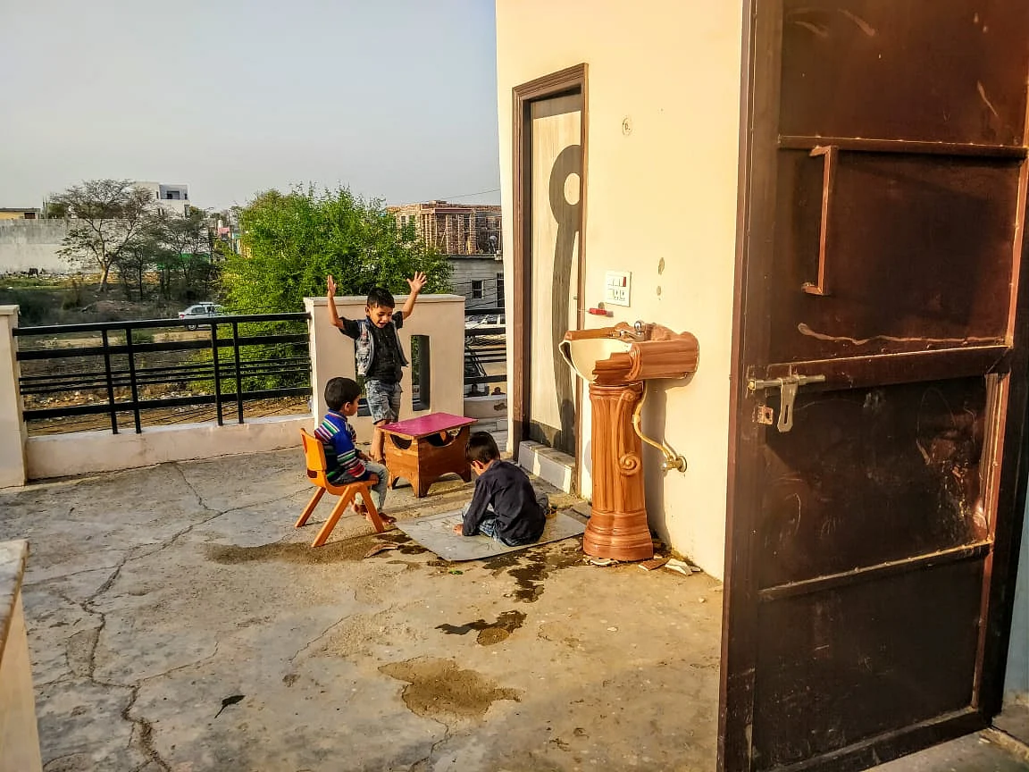 Kids of the house play behind the door that protected Daanishtha from the mob.