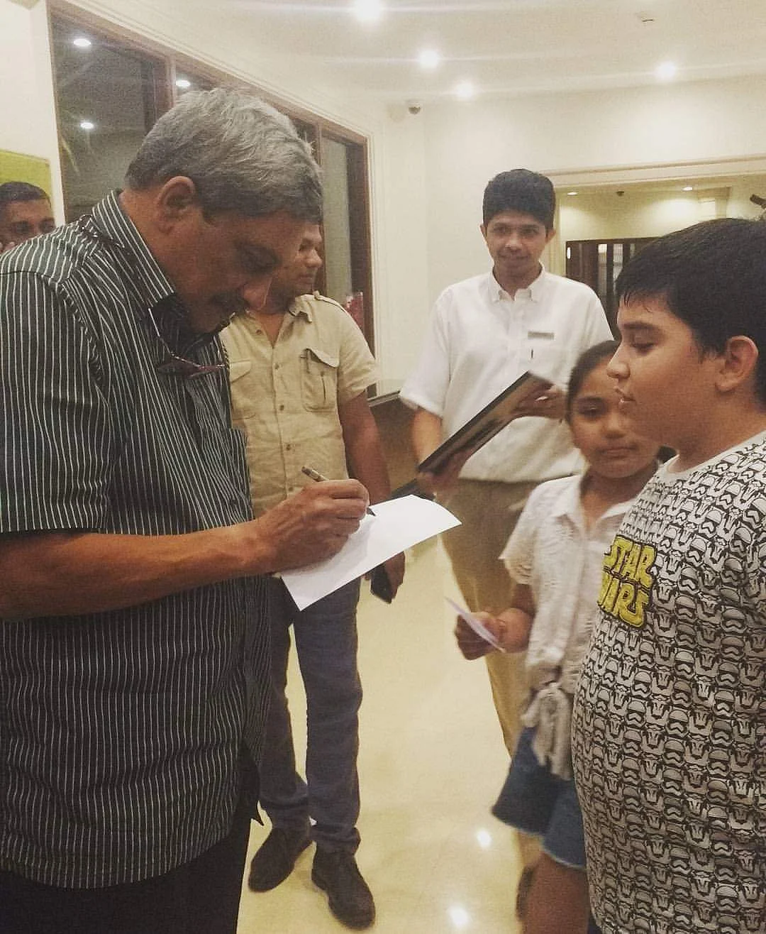 Manohar Parrikar signs an autograph for a kid.