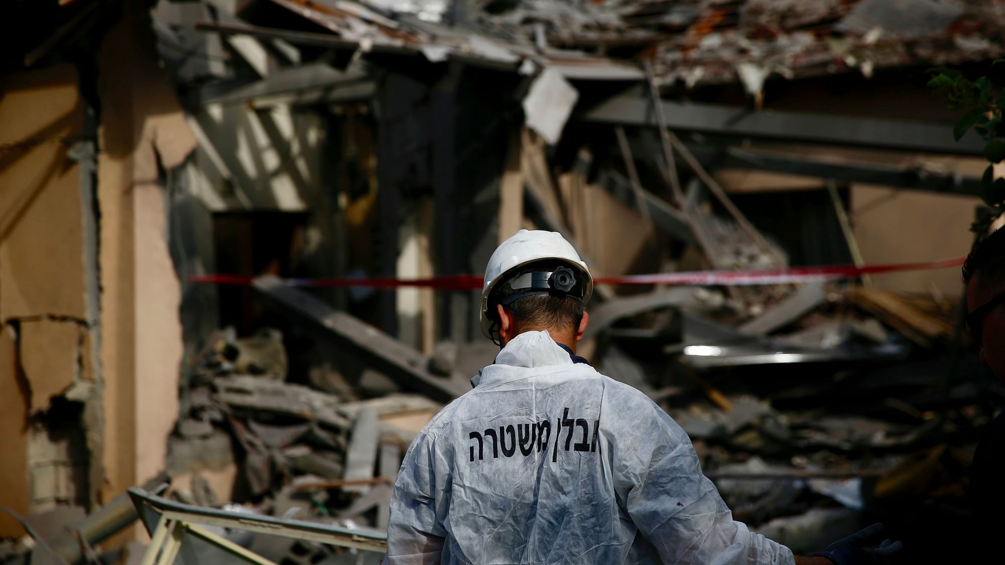 A rescue worker analyses the ruins of a damaged house hit by a rocket in Mishmeret, central Israel.