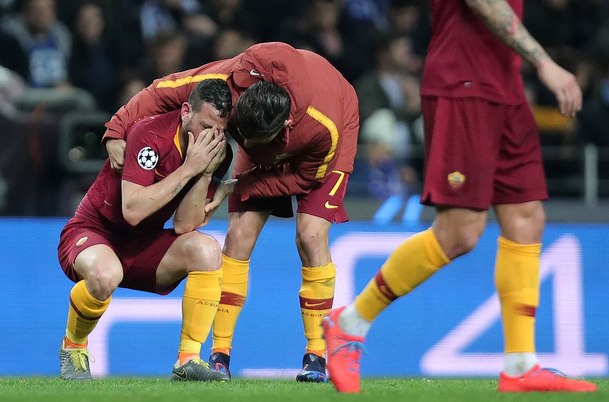Roma midfielder Lorenzo Pellegrini comforts midfielder Alessandro Florenzi, left, at the end of the Champions League round of 16, 2nd leg, soccer match.