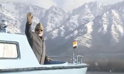 Prime Minister Narendra Modi waves his hand while taking a boat ride in Srinagar