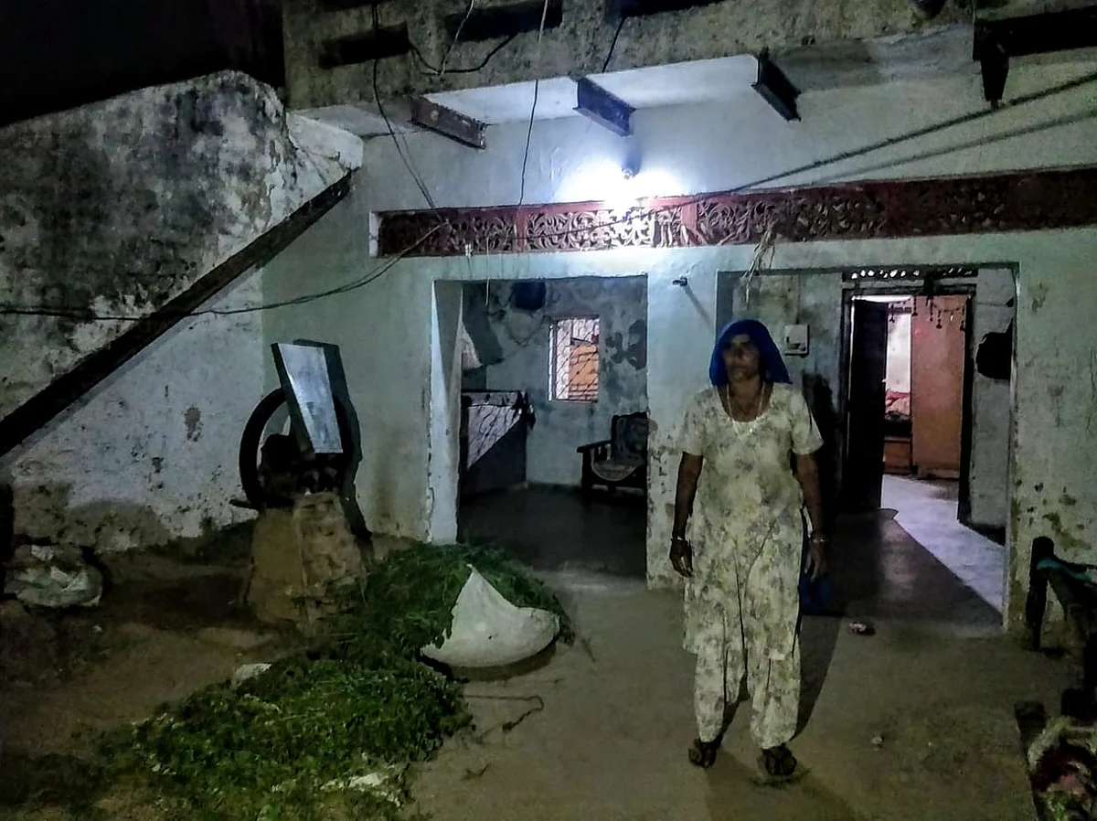 Mahesh’s mother stands inside their home in Naya Gaon. She takes up any work she gets to help feed her family. Her husband died about seven years ago.