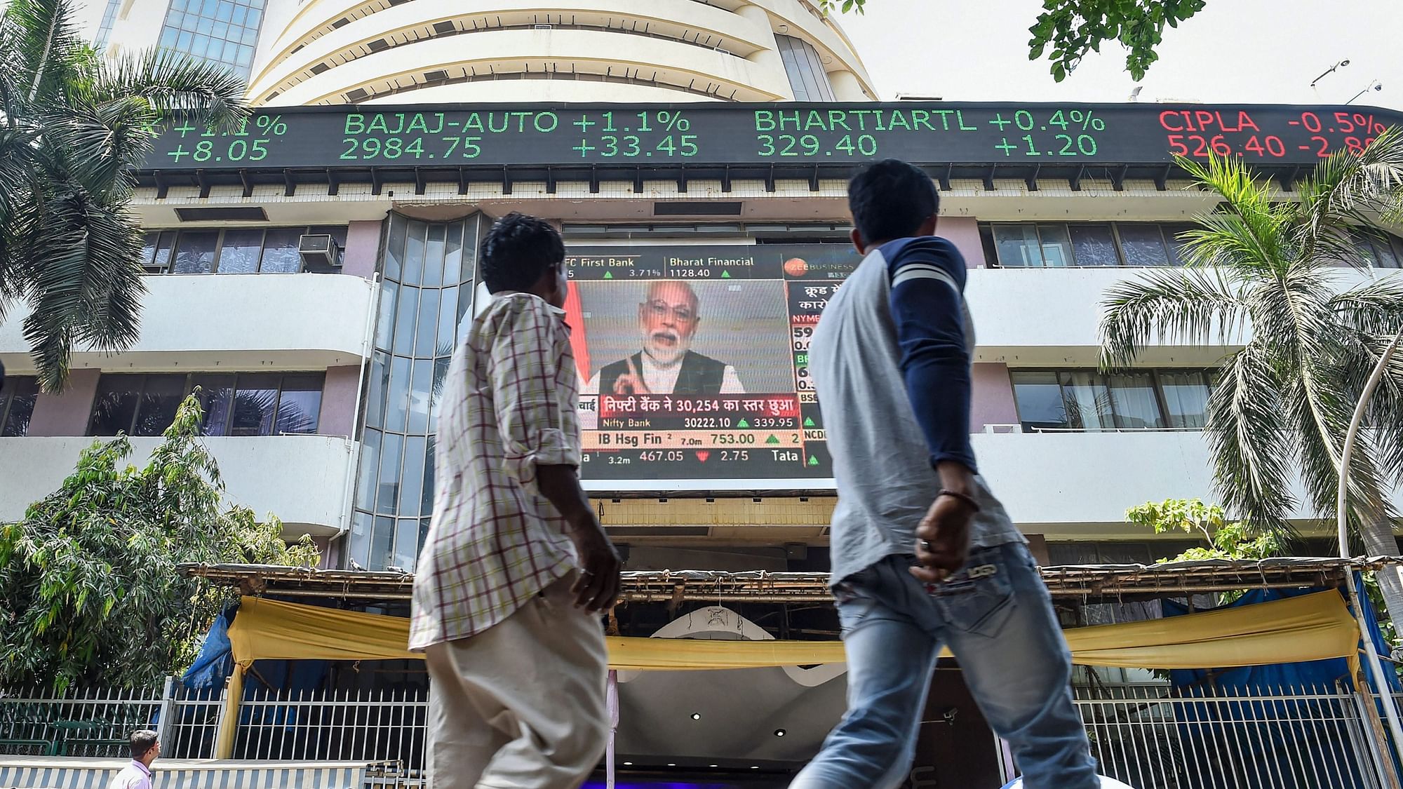 Passersby watch the live telecast of Prime Minister Narendra Modi’s address to the nation, on a screen outside Bombay Stock exchange, in Mumbai.