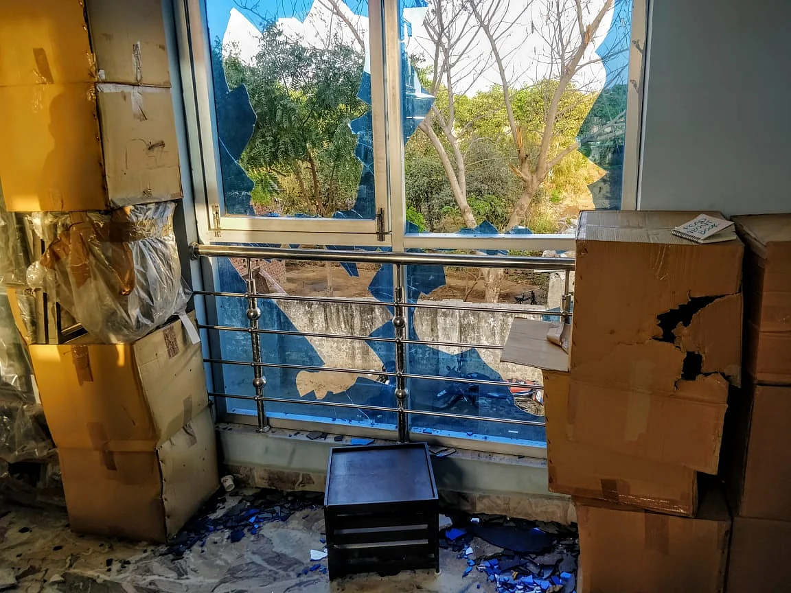Broken shards of glass scattered over the floor of the home two days after a mob of at least 25 men attacked their home. 