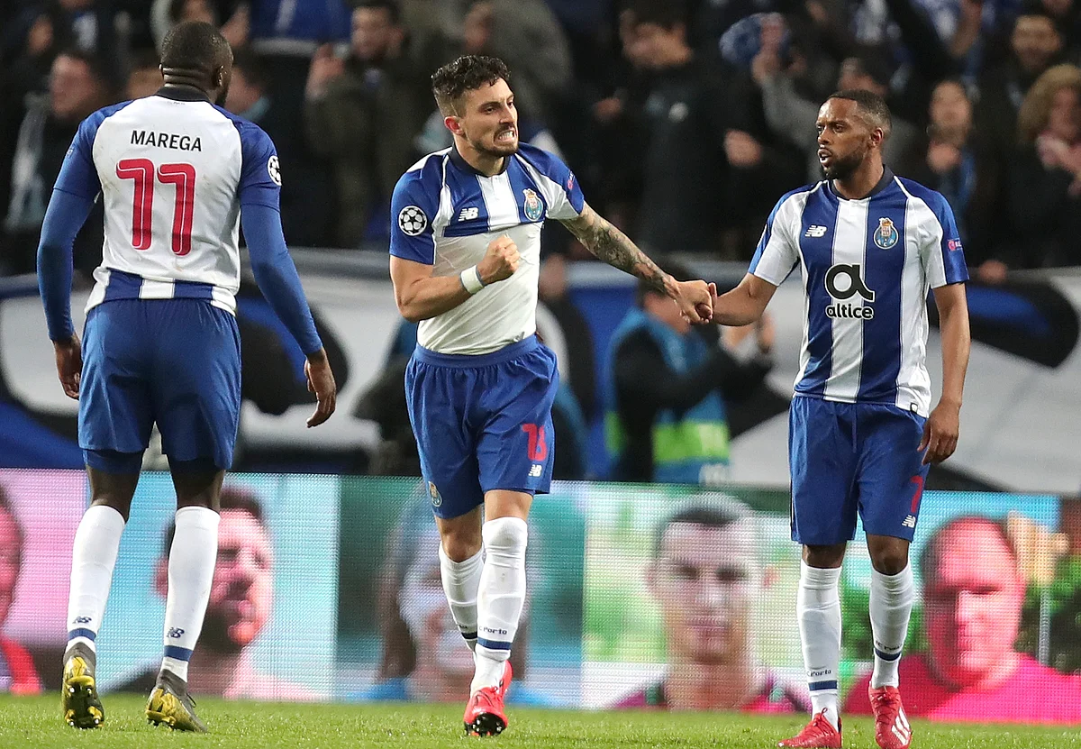 Porto defender Alex Telles, center, celebrates after scoring his side’s third goal during the Champions League round of 16, 2nd leg, soccer match.