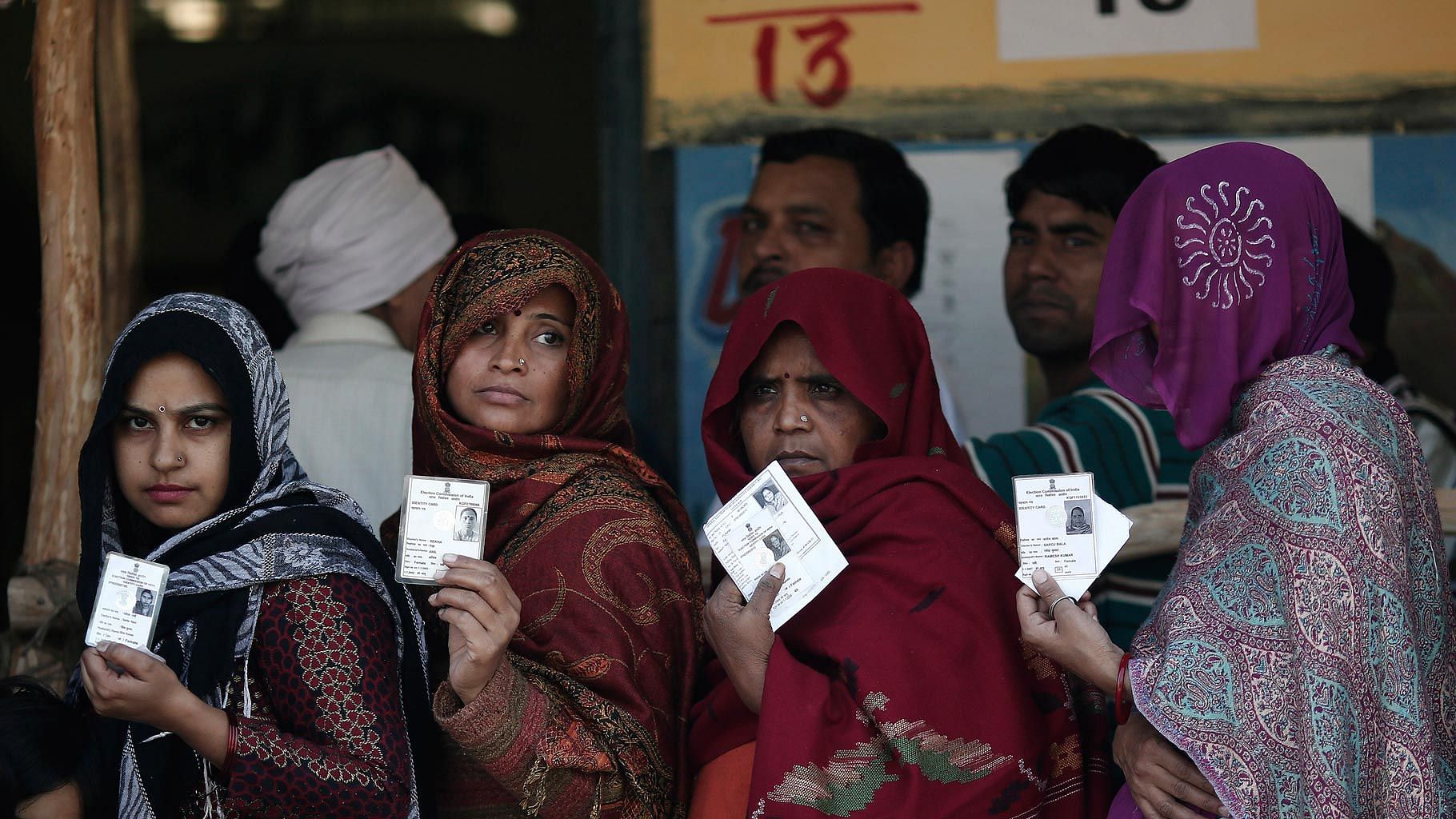 File photo of women showing their voter id cards before polling.