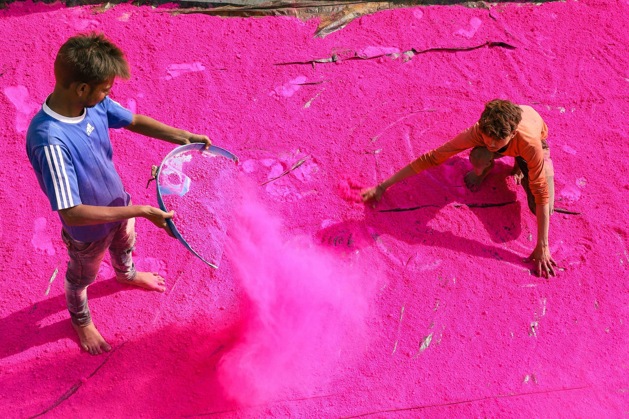 Workers sieve coloured powder to be used during the festival of Holi, at a factory in the outskirts of Jabalpur on Saturday, 16 March.