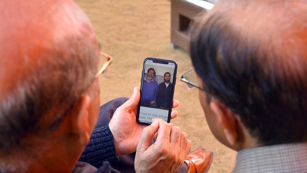 Relatives look the pictures of Pakistani citizen Rashid Naeem, and his son Talha Naeem, who were reportedly killed in the Christchurch mosque shooting, in a cell phone at their native home in Abbottabad, Pakistan on Saturday, 16 March, 2019.