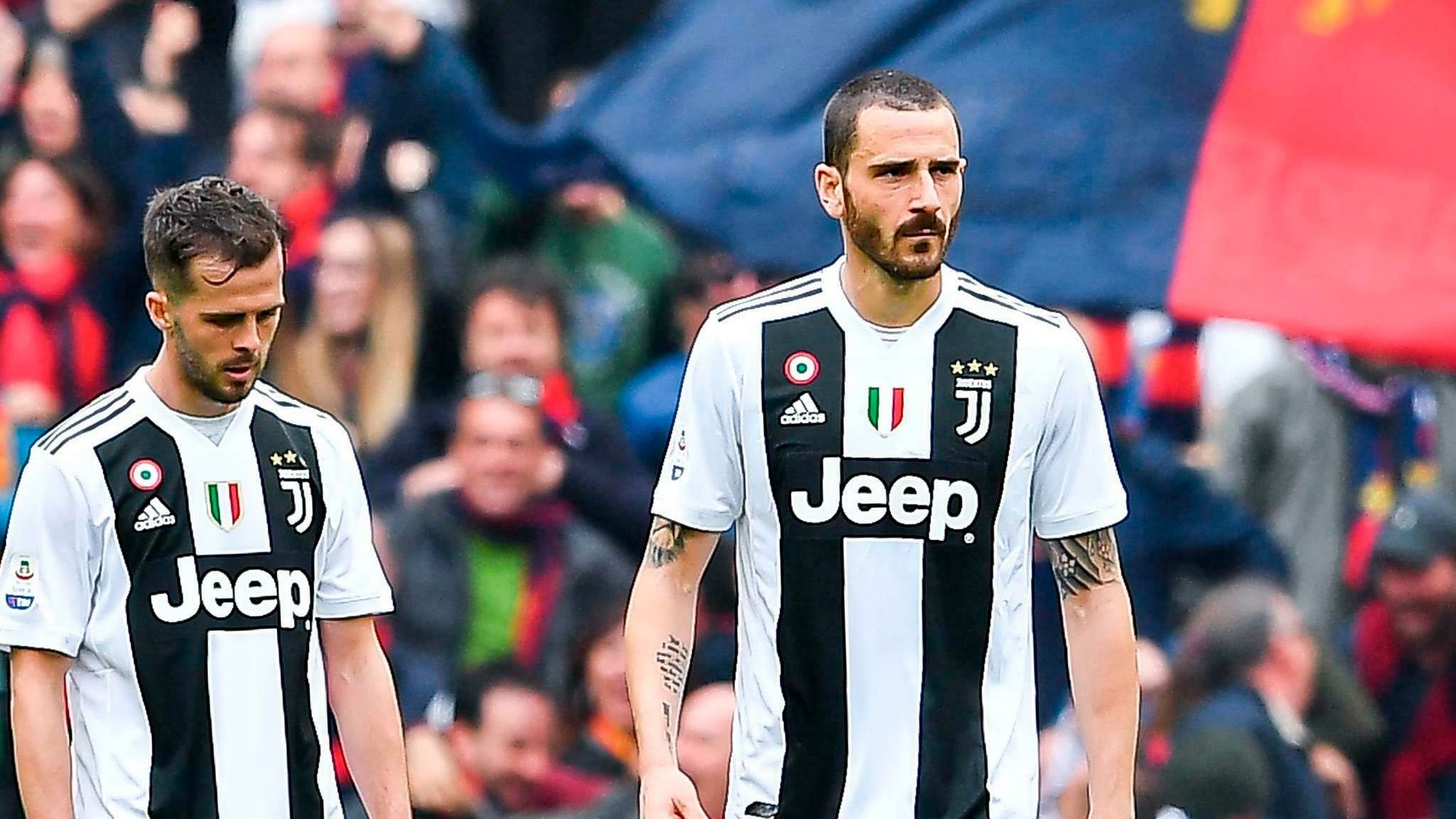 Miralem Pjanic (left) and Leonardo Bonucci walk in dejection after Juventus lost at Genoa to suffer their first defeat of the 2018/19 Serie A season.