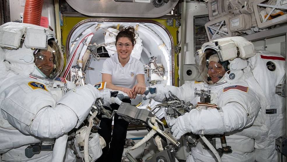 NASA astronaut Christina Koch (center) assists fellow astronauts Nick Hague (left) and Anne McClain in their U.S. spacesuits shortly before they begin the first spacewalk of their careers