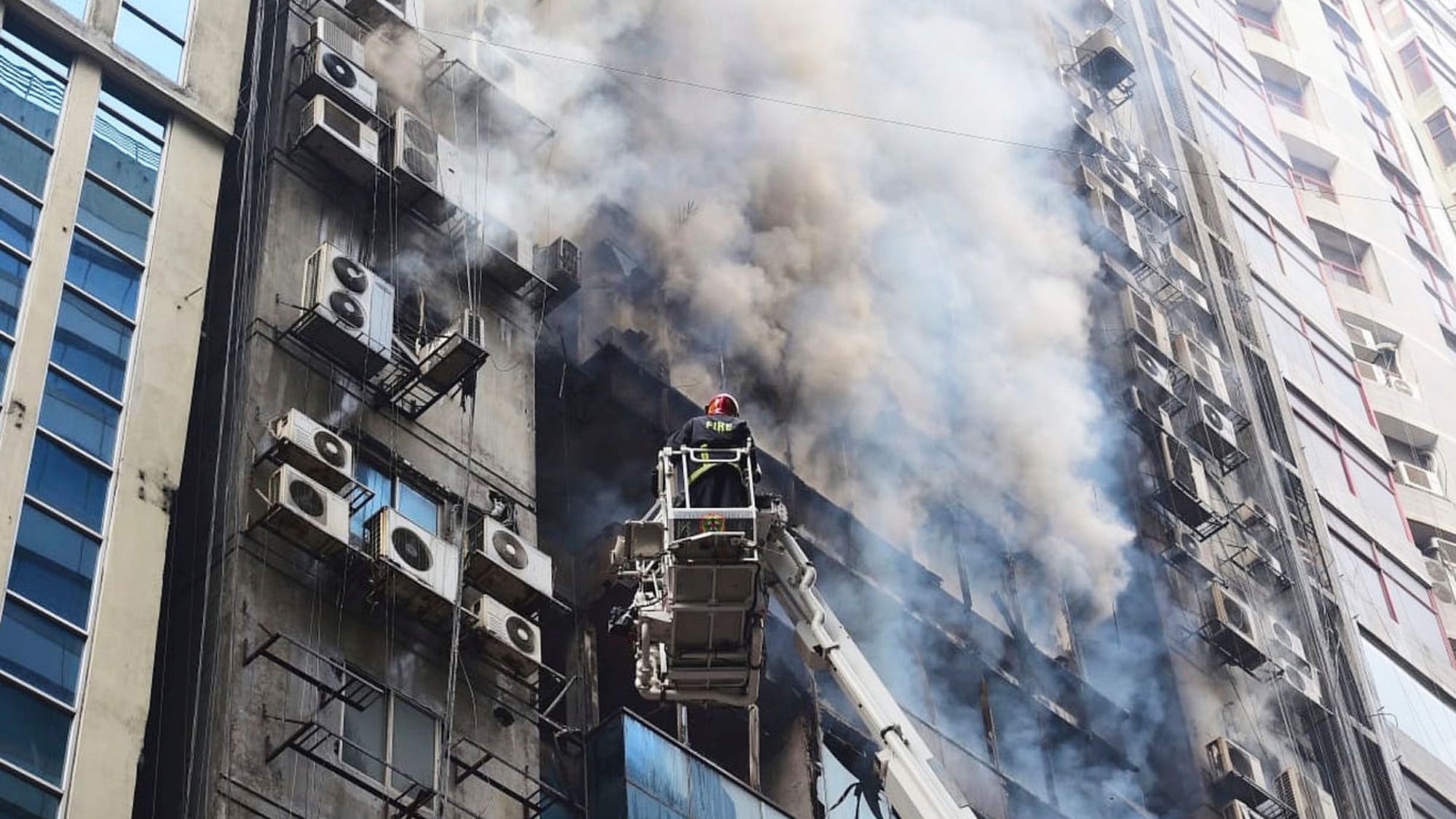 A firefighter works to douse a fire in a multi-storied office building in Dhaka, Bangladesh. 