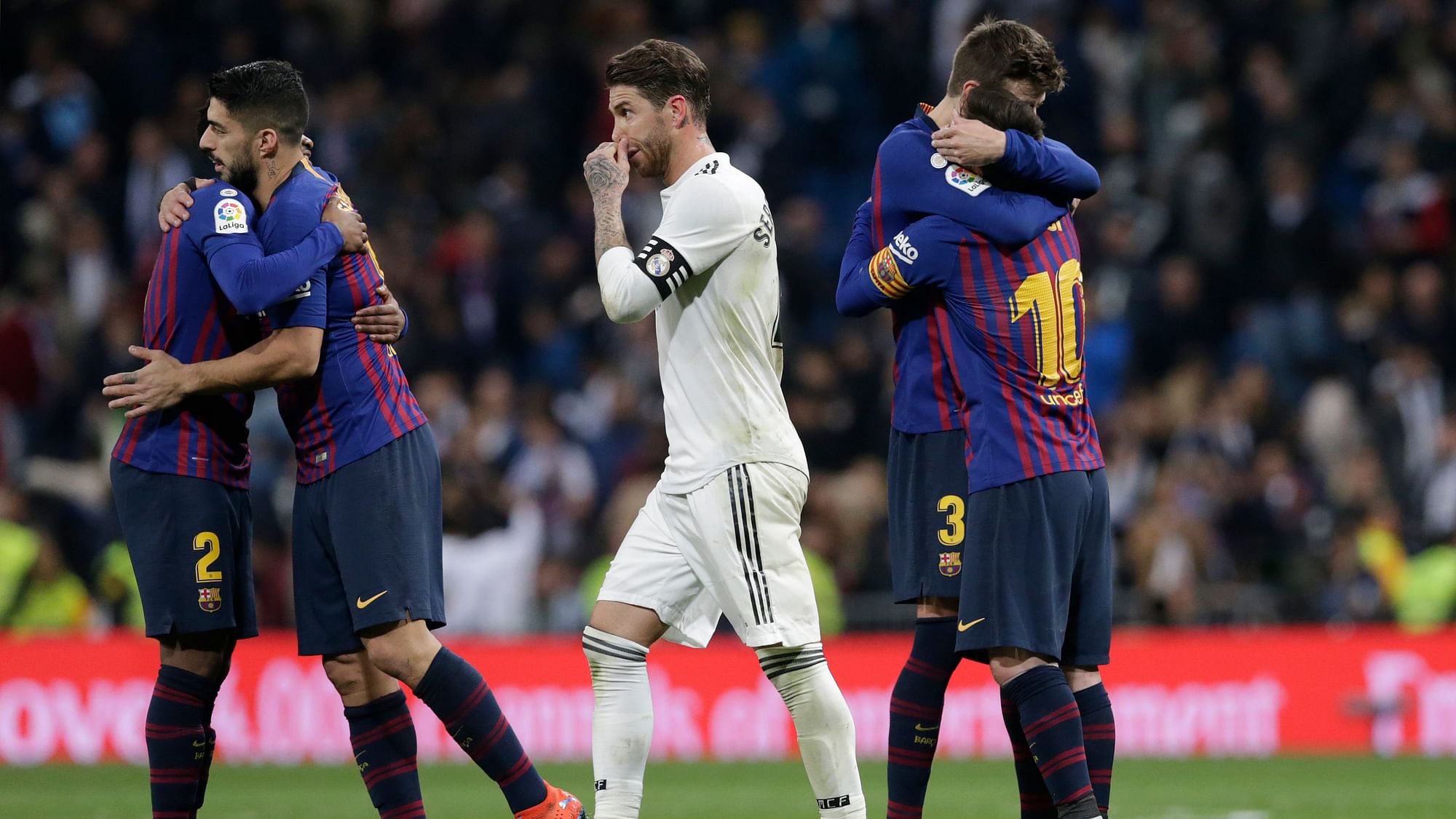 Real Madrid’s Sergio Ramos walks past Barcelona players celebrating after winning the La Liga match between Real Madrid and FC Barcelona at the Bernabeu stadium in Madrid on Saturday.