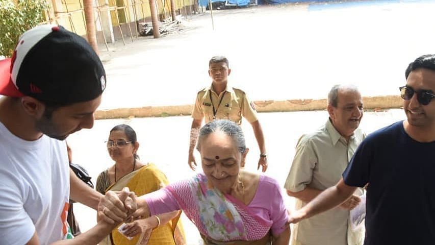 Varun Dhawan helps an old woman at polling booth.