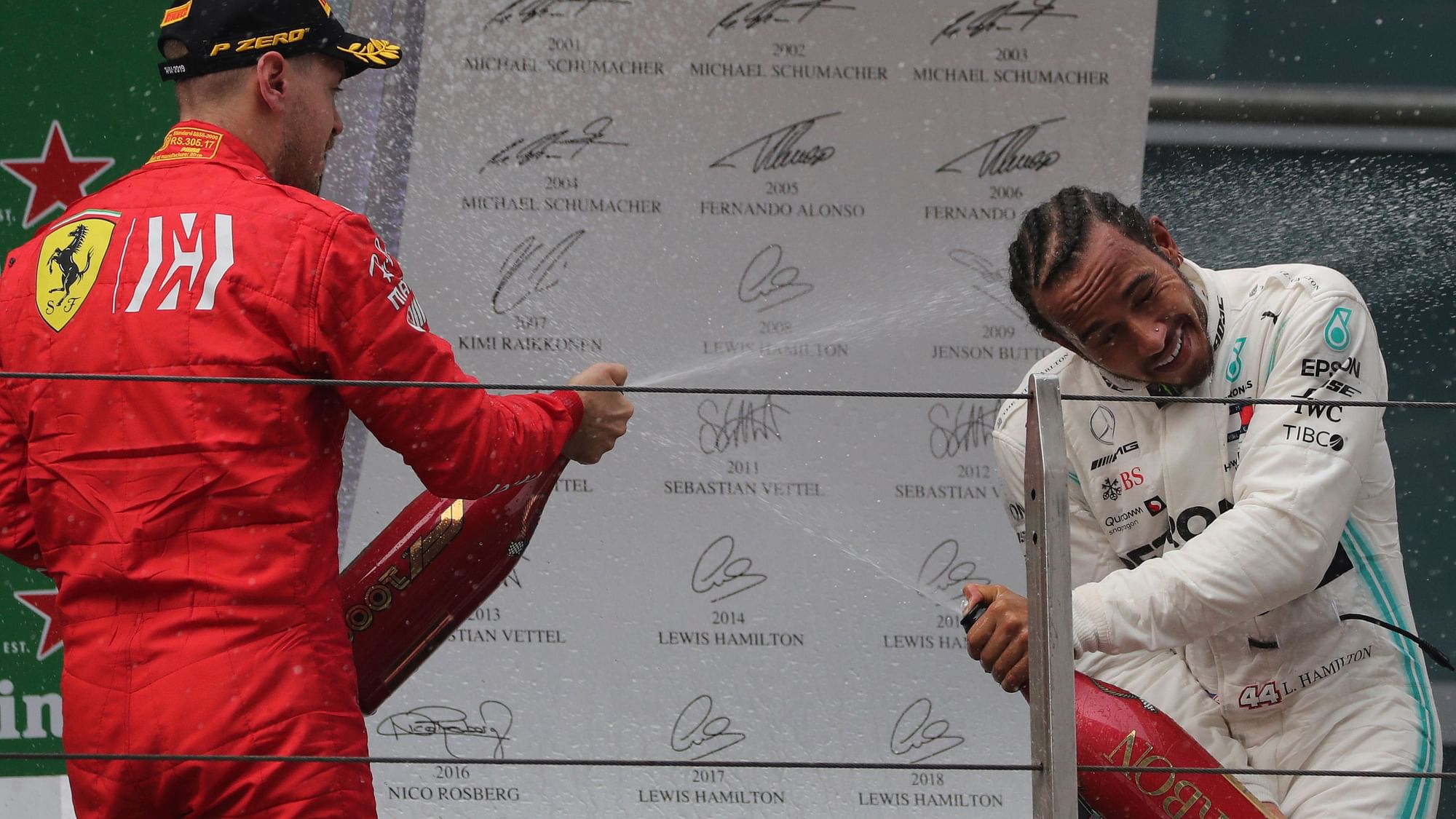 Lewis Hamilton of Britain is sprayed with champagne by  Sebastian Vettel during the award ceremony after the Chinese Formula One Grand Prix.