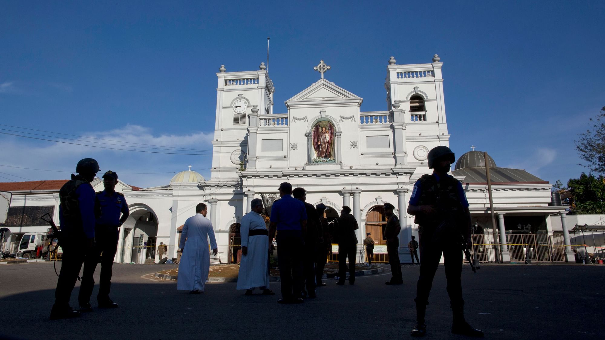Sri Lankan air force officers and clergy stand outside St Anthony’s Shrine, a day after a blast in Colombo.
